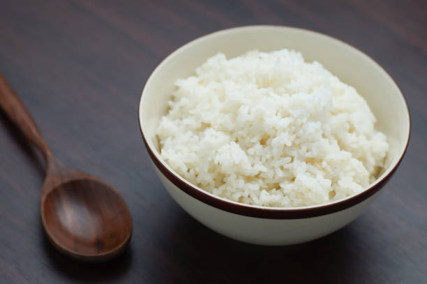 istock Thai rice in bowl with wooden spoon on table 690224308