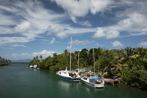 Tropical skies over boats in sea side harbour in Fiji