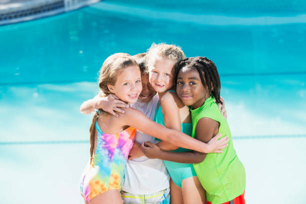 istock Multi-ethnic children in group hug by swimming pool 690224772