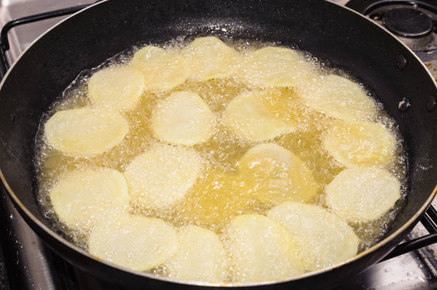 istock Frying rounded potatoes on a black pan with boiling oil 690224862