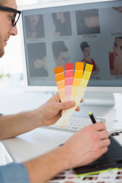 istock Handsome designer working with digitizer holding colour chart at his desk 690224872