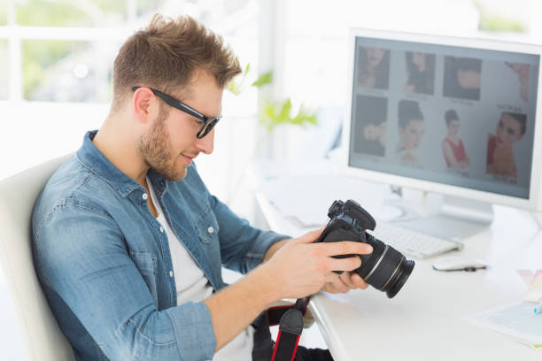istock Handsome photographer looking at his camera 690224908