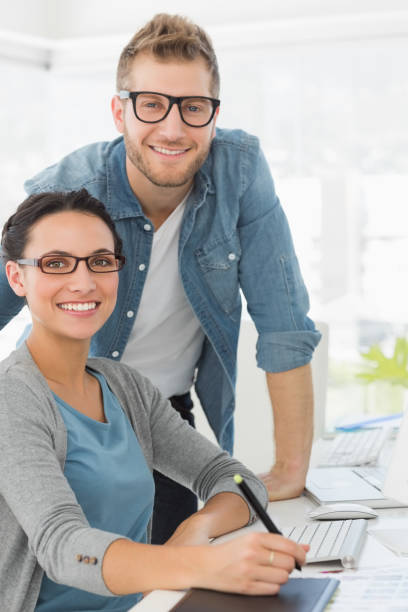 istock Young attractive design team at desk smiling at camera 690227028