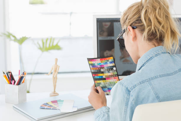 istock Blonde designer looking at colour chart at desk 690227334