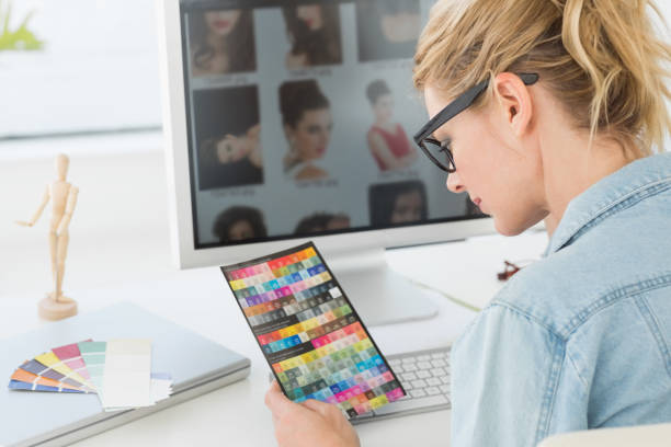 istock Blonde designer looking at colour chart at her desk 690227346