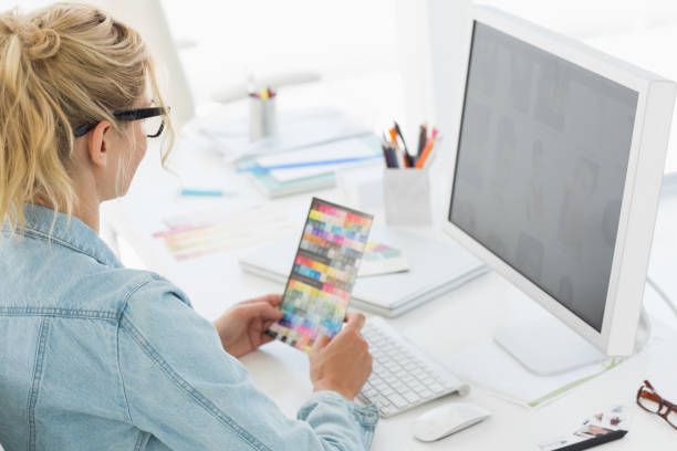 istock Blonde designer holding colour swatch at her desk 690227358