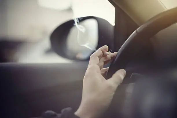 Smoking cigarettes at the wheel while driving a car.