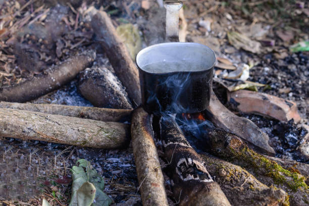 istock Boiling water using bonfire on vacation at campsite. 690229680