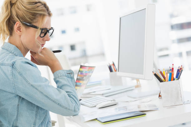 istock Blonde focused designer working at her desk 690235678