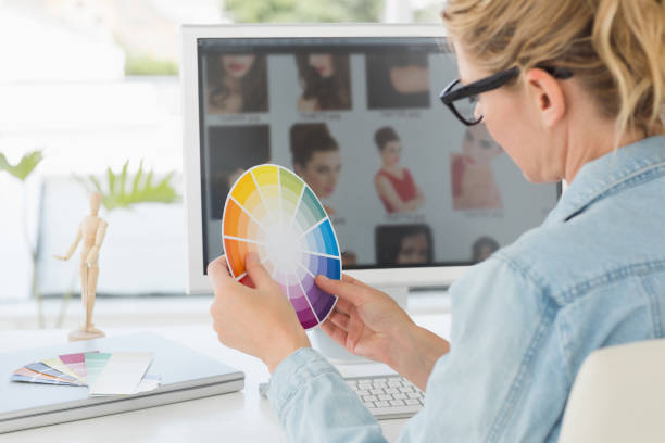 istock Blonde focused designer working at her desk holding a colour wheel 690235702
