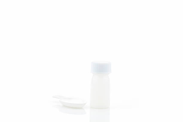 istock White plastic medical container with realistic medical measuring spoon isolated on white background. 690235896