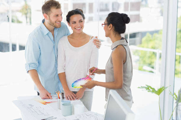 istock Interior designer showing colour wheel to happy young clients 690236004