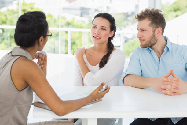 istock Therapist talking with couple sitting at desk 690236314