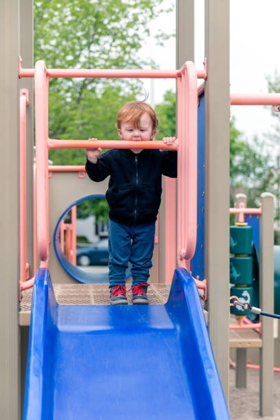 istock Baby Boy Sliding on Slide at the Park 690239818