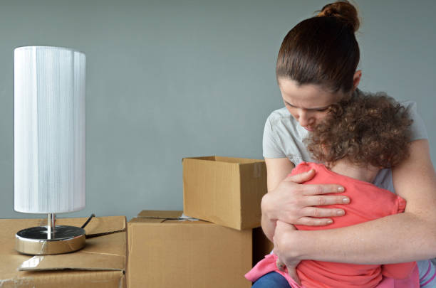Sad evicted mother with child worried relocating house Sad evicted mother (age 30-35) with child (age 2-3) worried relocating house.  Moving house concept. Real people. copy space eviction photos stock pictures, royalty-free photos & images