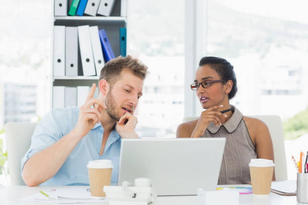 istock Partners working together at desk on laptop 690244558