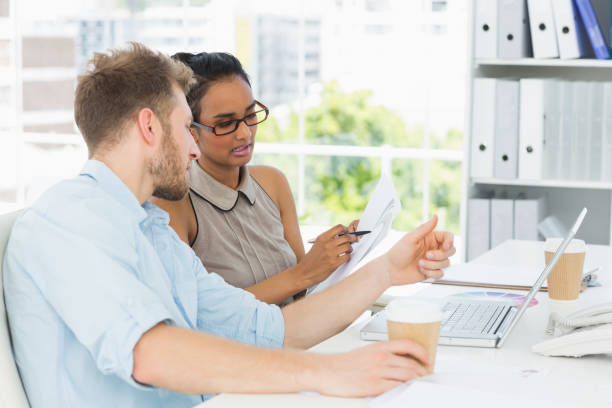 istock Focused business partners working together on laptop at desk 690244582