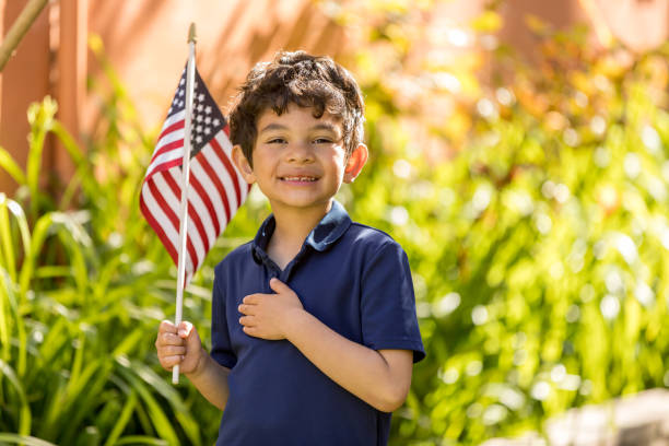 patriótico garoto segurando uma bandeira americana fora de sua casa - child flag patriotism thumbs up - fotografias e filmes do acervo