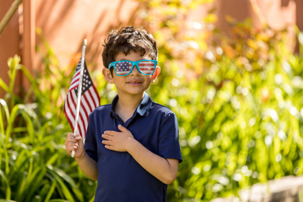 patriótico garoto segurando uma bandeira americana fora de sua casa - child flag patriotism thumbs up - fotografias e filmes do acervo