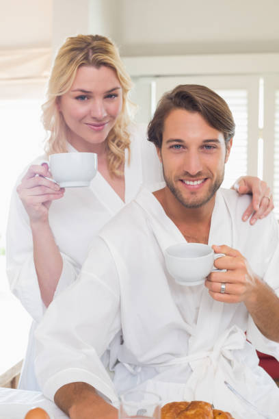 istock Cute couple in bathrobes having breakfast together 690251532