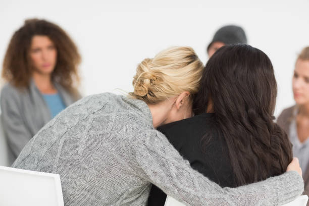 istock Women embracing in rehab group at therapy 690252106