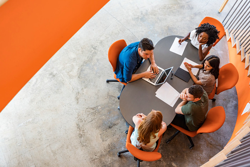 Top down view of a group of young entrepreneurs working together in a start up business meeting