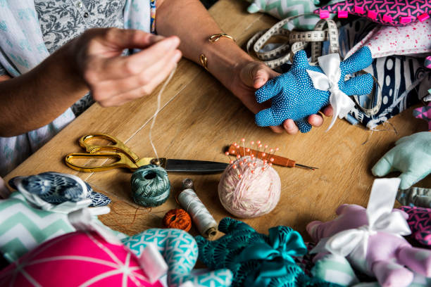 istock Woman sewing handmade doll on the table 690256332