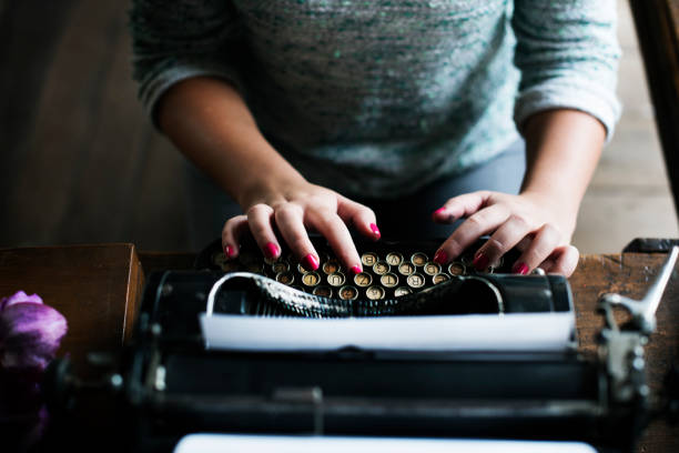 istock Woman typing vintage typewriter on wooden table 690256368