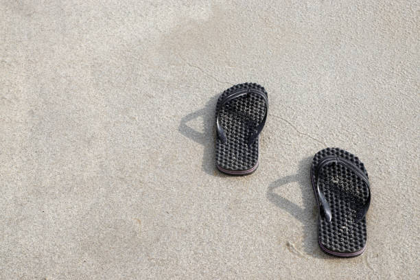 istock Black Slipper (Sandals) on the sandy tropical beach, Summer Holiday. 690266604