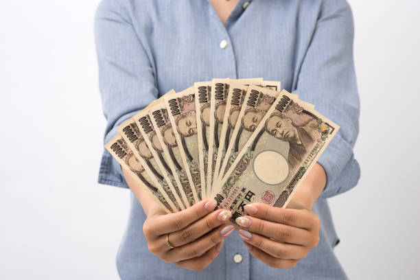 a japanese young woman counting ten thousand yen - money roll fotos imagens e fotografias de stock