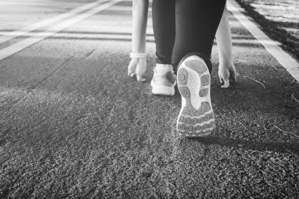 istock Young lady running on road closeup on shoe., at time sunset 690269976