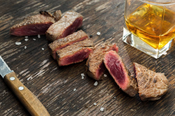 위스키와 나무 테이블에 구운된 쇠고기 스테이크를 슬라이스 - food and drink steak meat food 뉴스 사진 이미지
