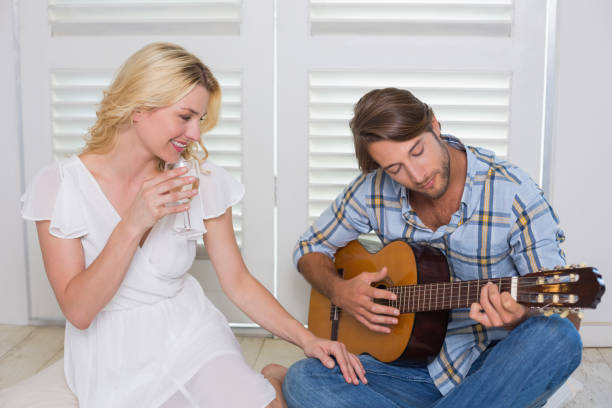 istock Handsome man serenading his girlfriend with guitar 690273900