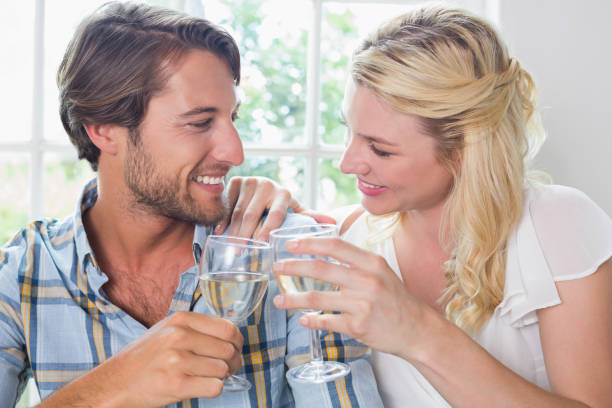 istock Cute smiling couple enjoying white wine together 690274216