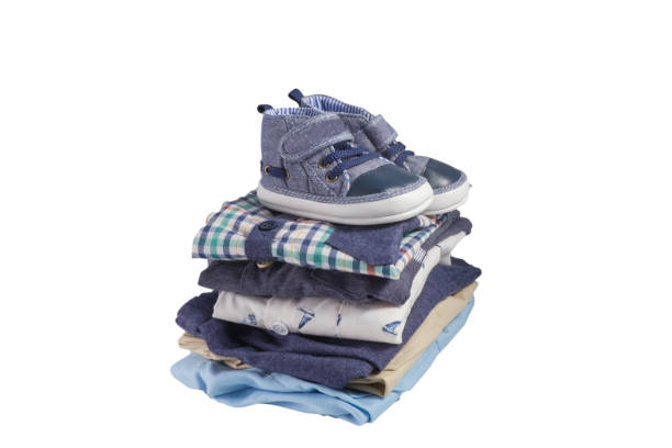 Toddler shoes and pile of clothes isolated on white stock photo