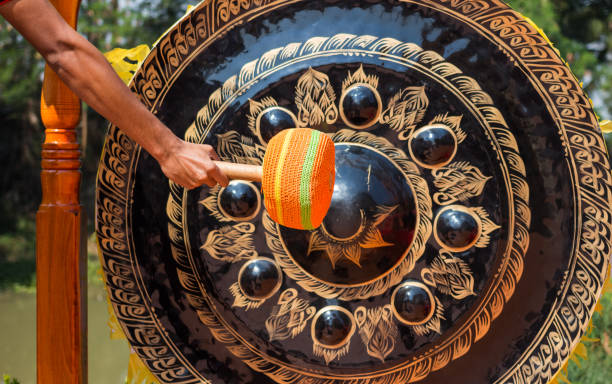 Traditional gamelan musicians in action, with a focus on the glistening metallophones and the rhythmic mallet strikes