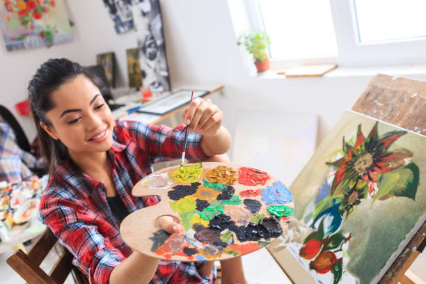 istock Young woman sitting and drawing at home 690277202