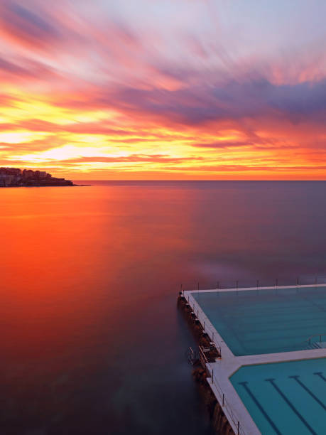 Icebergs Red Sunrise Bondi Icebergs pool at cloudy red sunrise bondi beach sunrise stock pictures, royalty-free photos & images