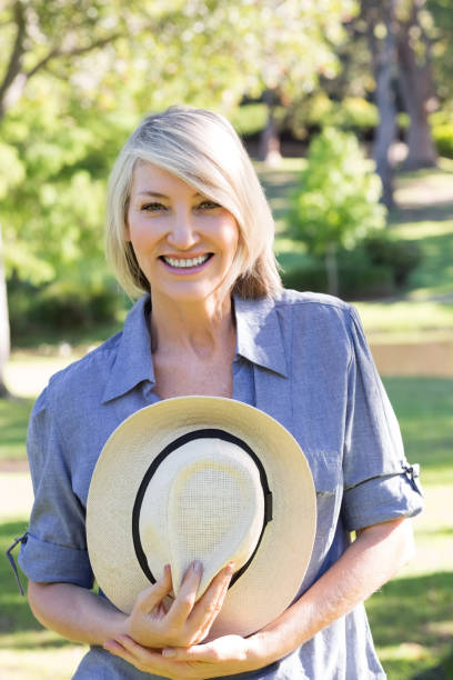 istock Woman holding sunhat in park 690285250