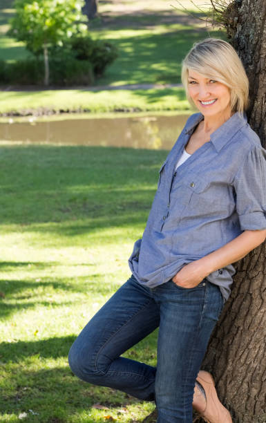 istock Woman leaning on tree trunk in park 690285400
