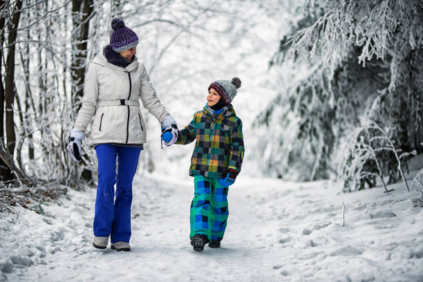 istock Mother and son walking in beautiful winter forest 690285456