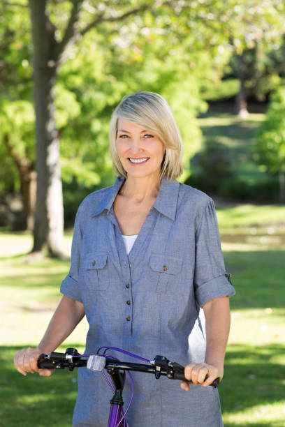istock Woman with bicycle in park 690285532