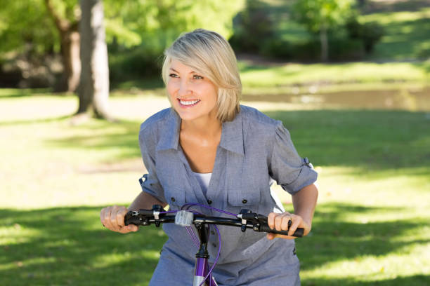 istock Woman riding bicycle in parkland 690287276