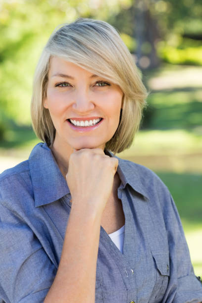 istock Woman with hand on chin in park 690287574