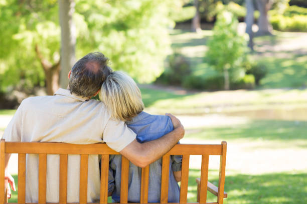 istock Couple relaxing on park bench 690287788