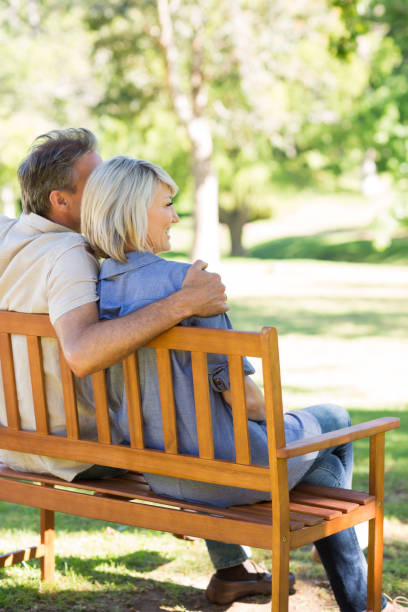 istock Couple relaxing on park bench 690287816
