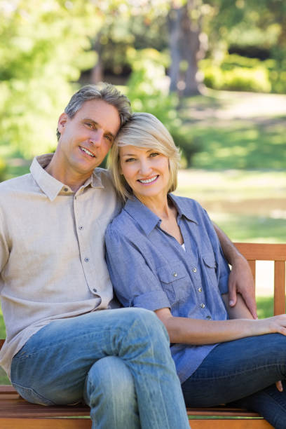 istock Smiling couple sitting on park 690287840
