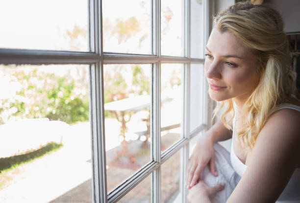 istock Pretty blonde looking out the window 690288062