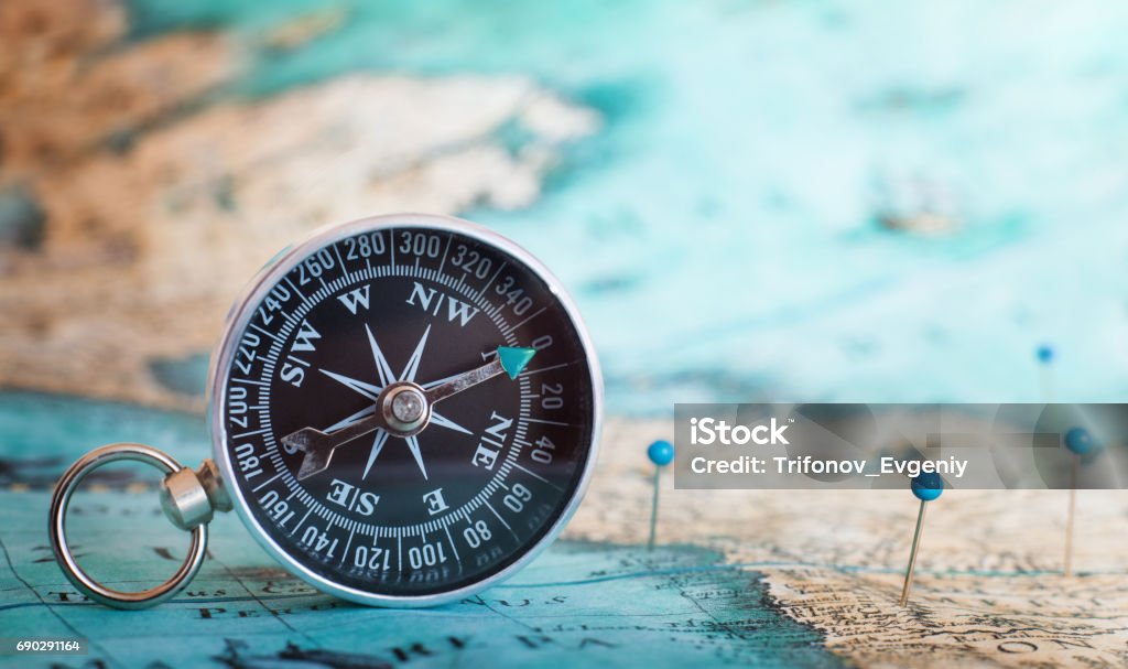 Compass on the map Black compass on the map Navigational Compass Stock Photo