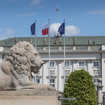 WARSAW, POLAND - JULY 09, 2015: Lion and Prince Jozef Poniatowski statue seen in the distance, by Danish sculptor Bertel Thorvaldsen, in front of the courtyard of the Presidential Palace